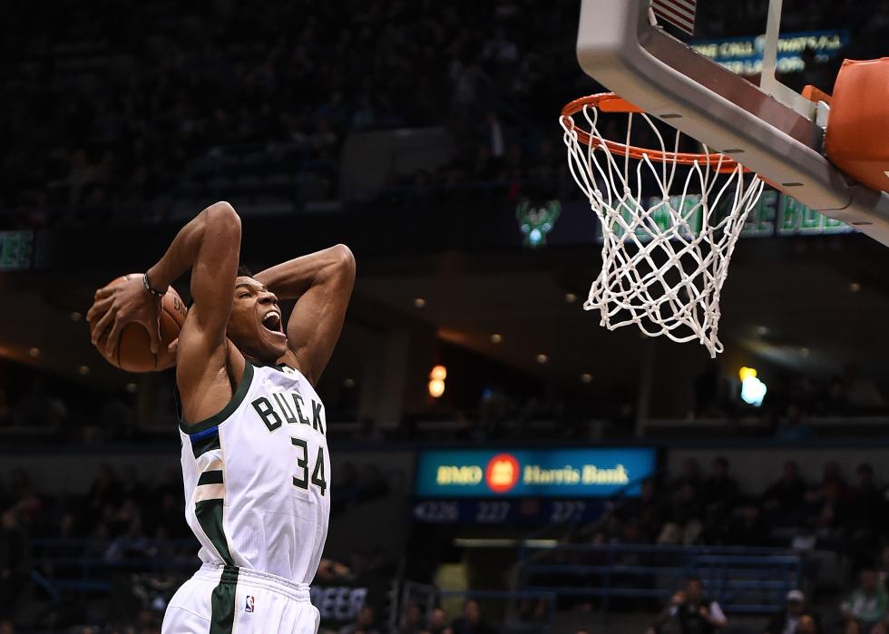 Side view of Giannis Antetokounmpo dunking a ball during a game