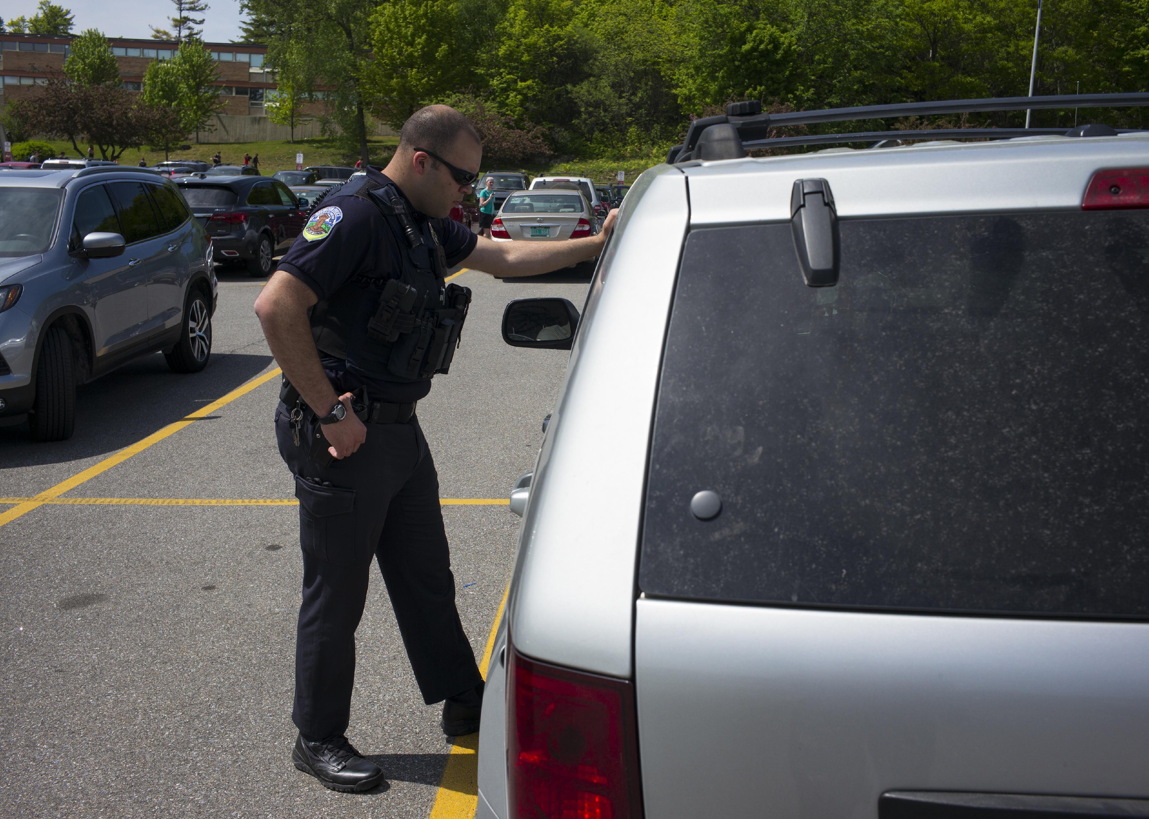 A member of the Burlington Police Department questions a person.