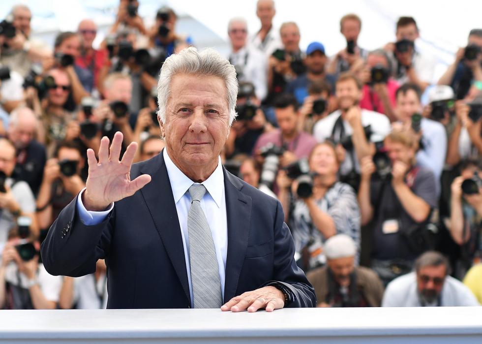 Dustin Hoffman waving with a large crowd behind him.