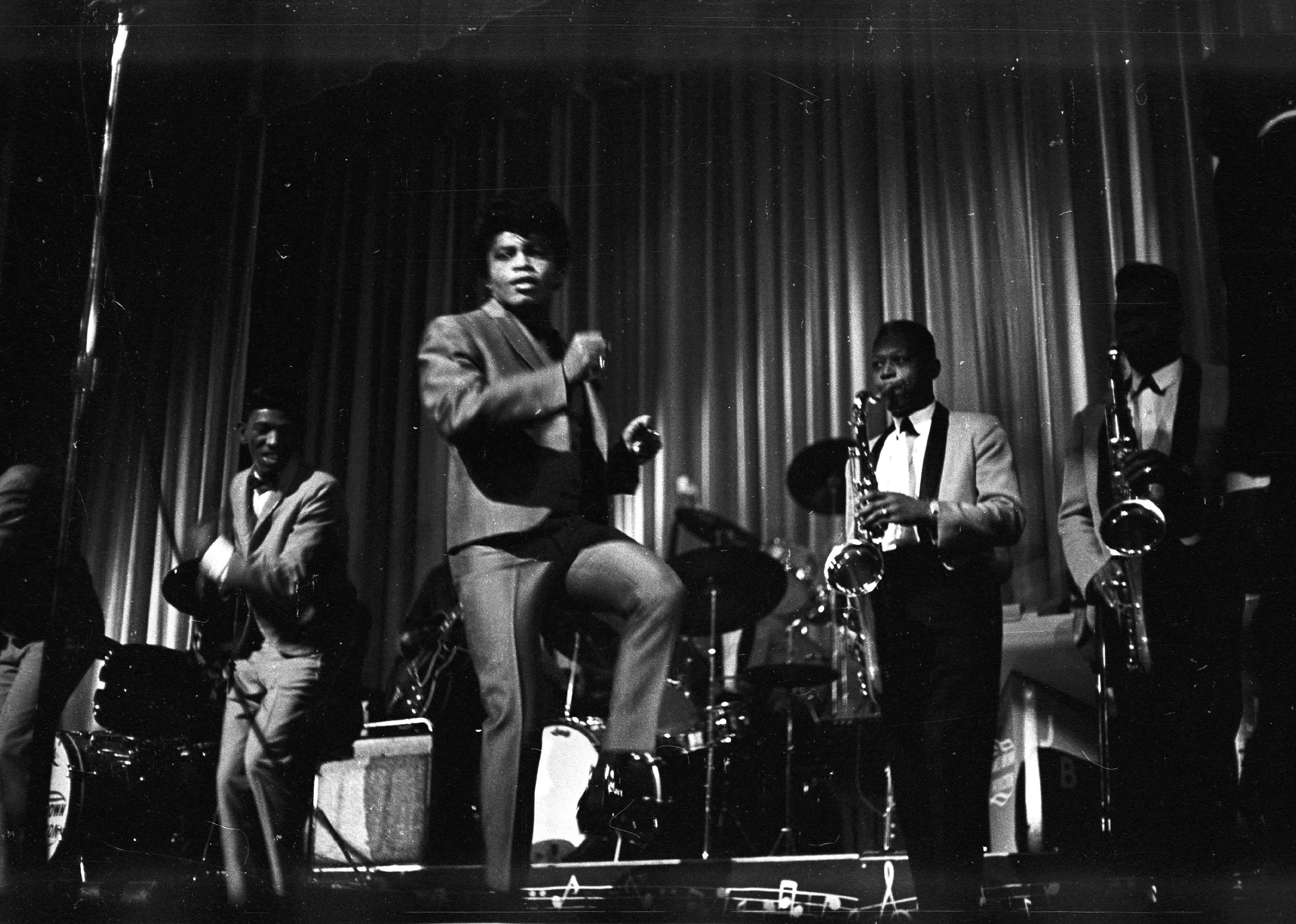 James Brown performs onstage at the Apollo Theatre.