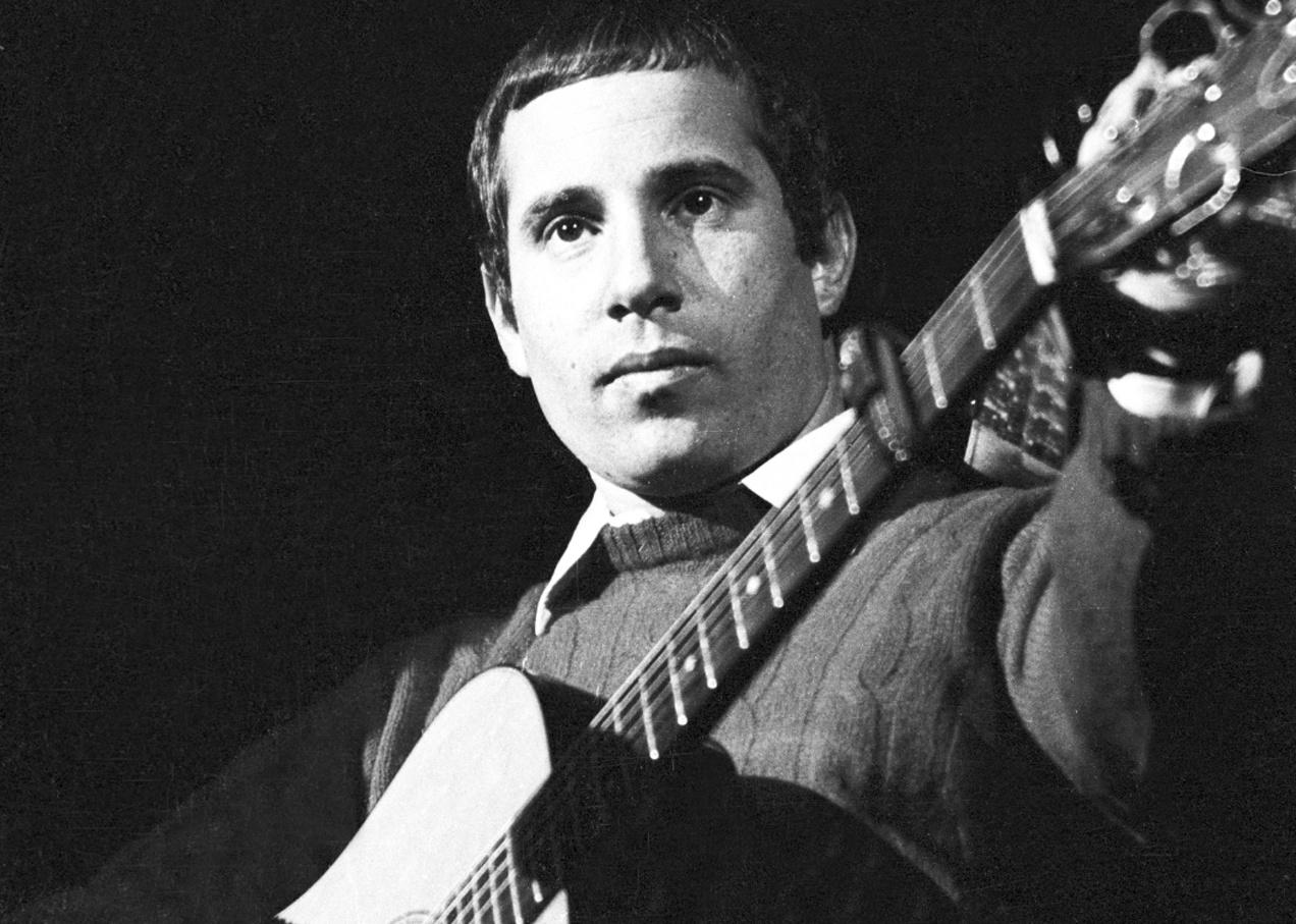 Close up of Paul Simon with a guitar.