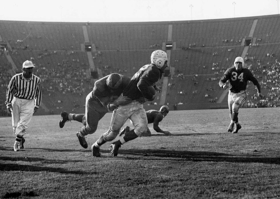 Charley Trippi of the Chicago Cardinals tries to avoid being tackled by Rams defender Pat Harder