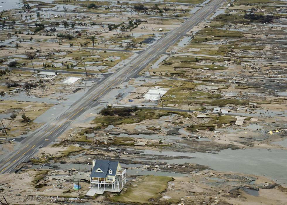 One house stands on a street that has been levelled by a storm.