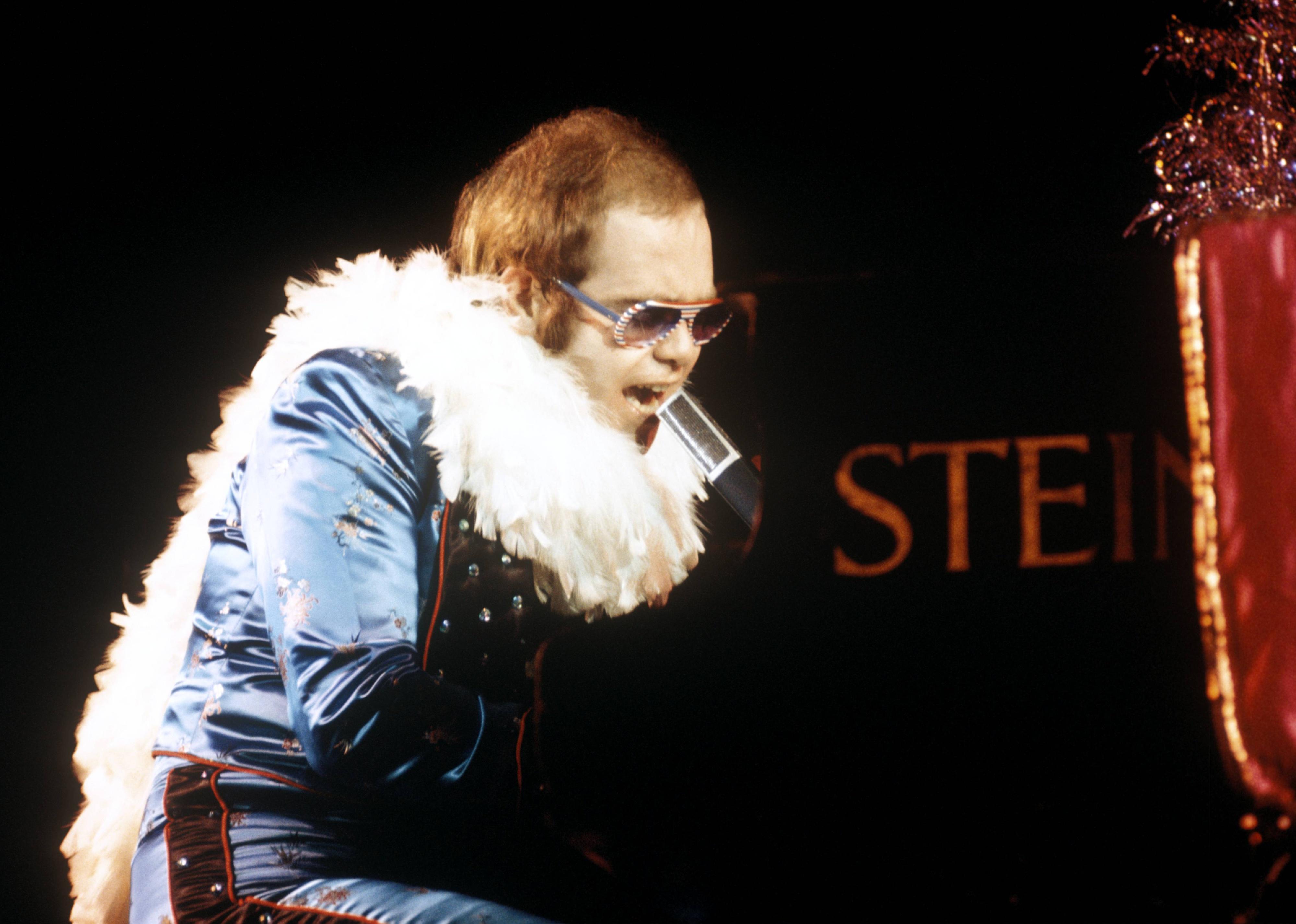 Elton John playing piano and singing.