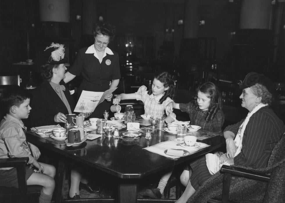 A waitress takes order from a family out at a restaurant
