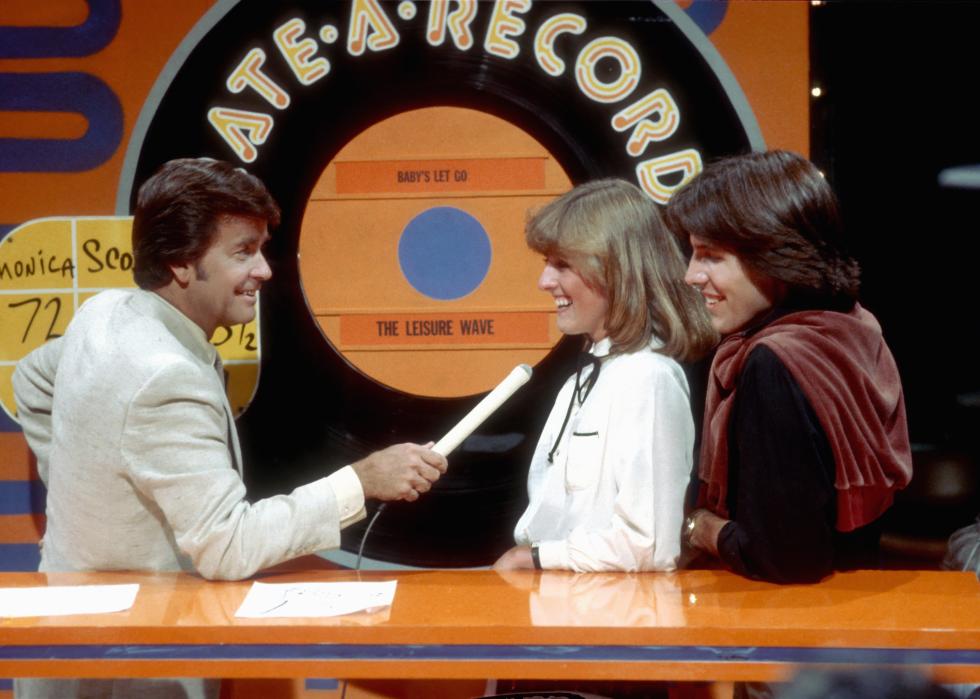 Dick Clark talking to members of the studio audience during 'American Bandstand' 