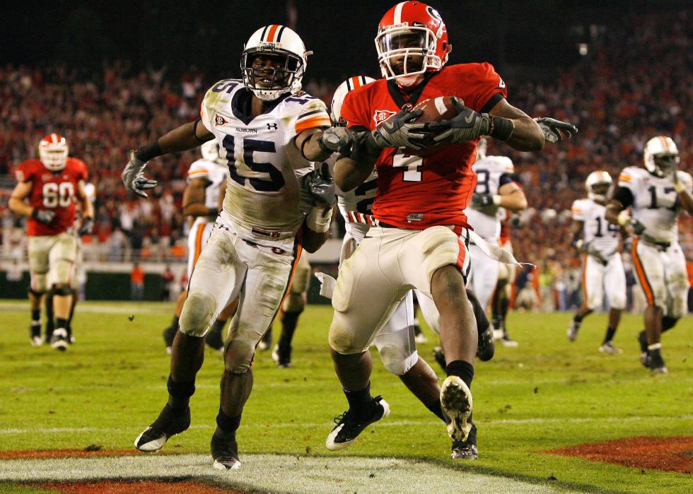 Tailback Caleb King of the Georgia Bulldogs runs in for the winning touchdown past defensive back Neiko Thorpe of the Auburn Tigers