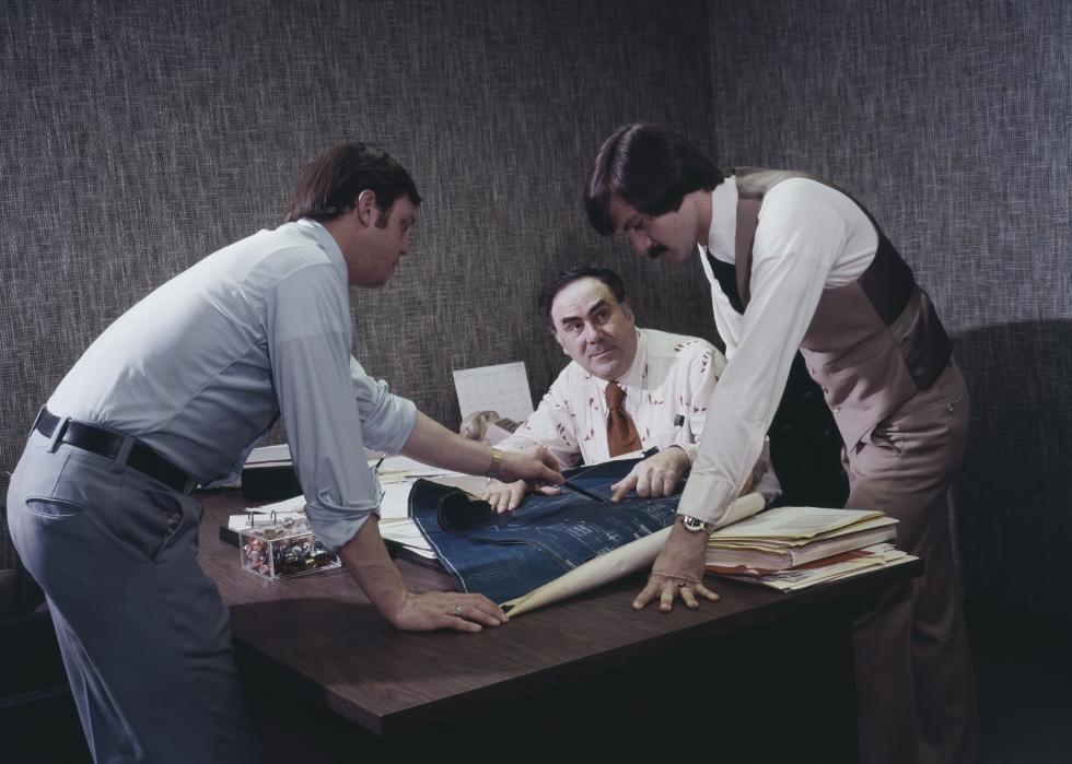 Businessmen preparing blueprint in office