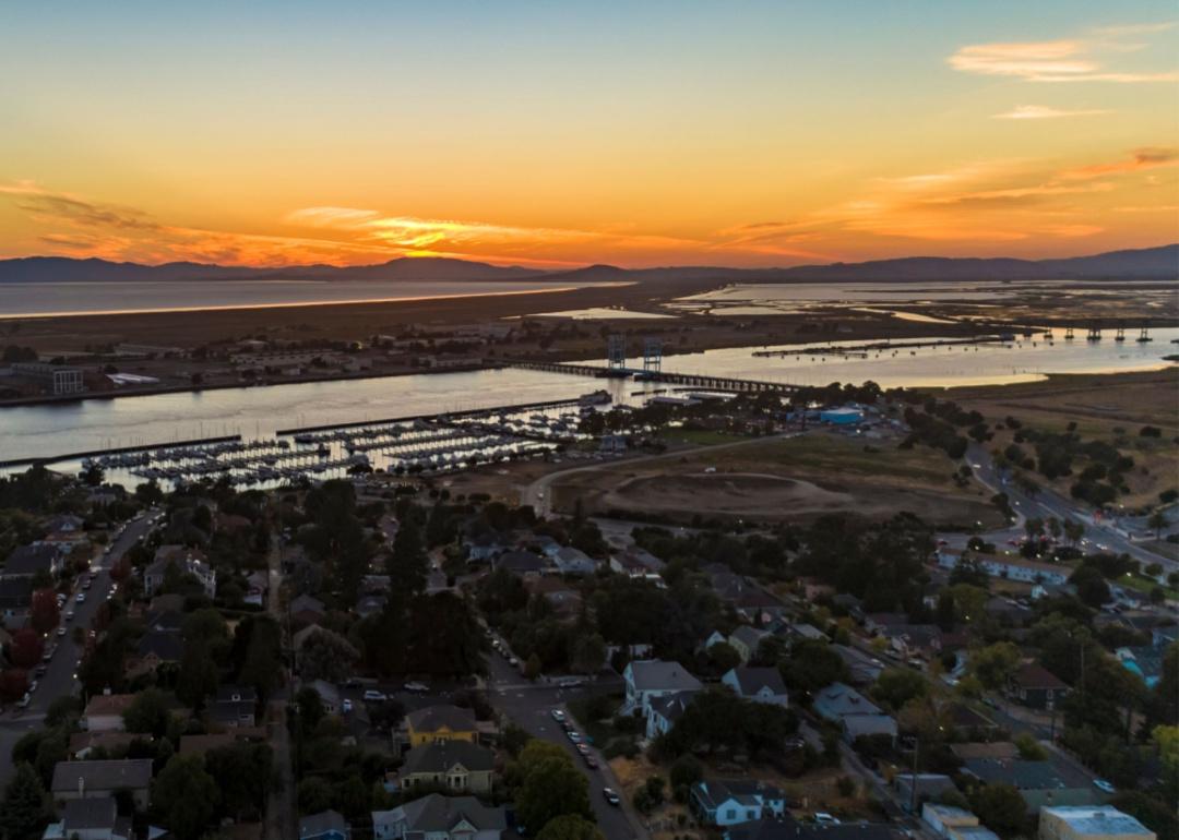 Sunset over Vallejo casting orange light over the calm Napa River punctuated by a draw-bridge and a yacht club.