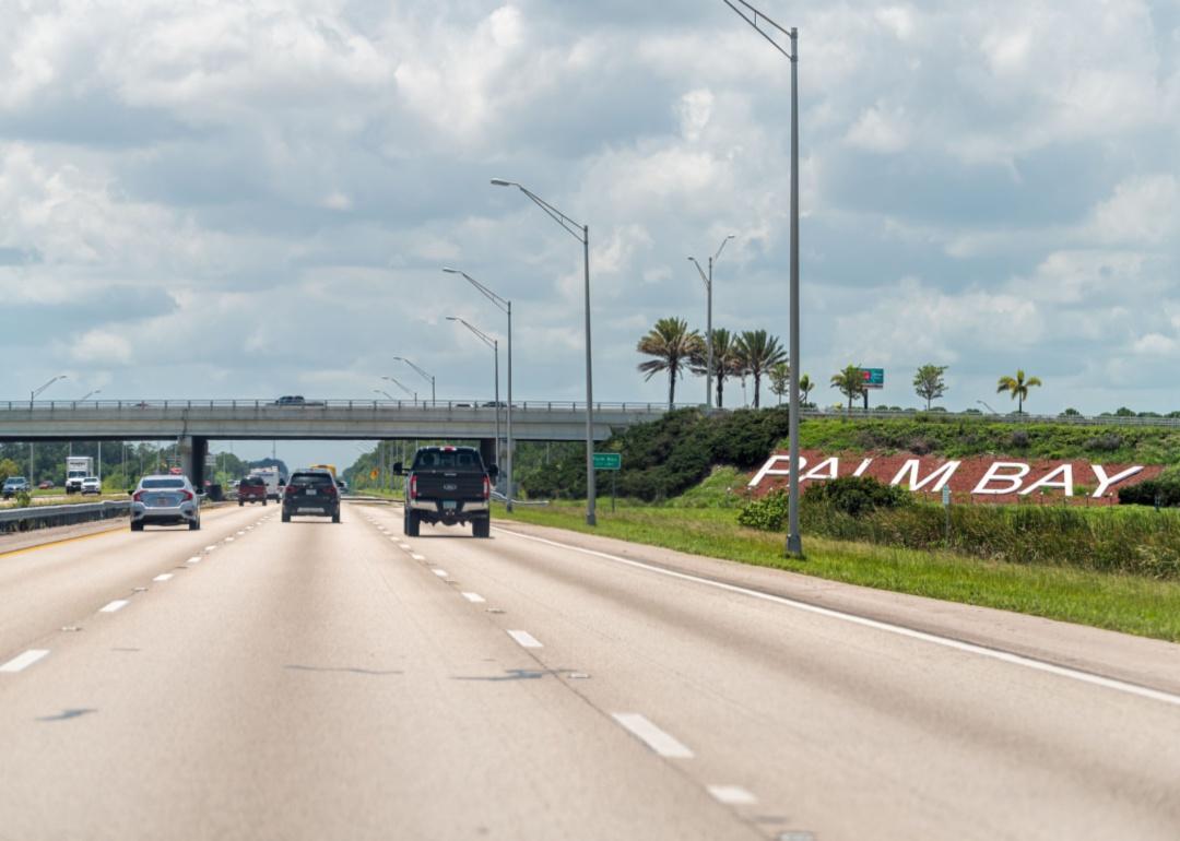 A highway with a sign leading into Palm Bay, Florida.