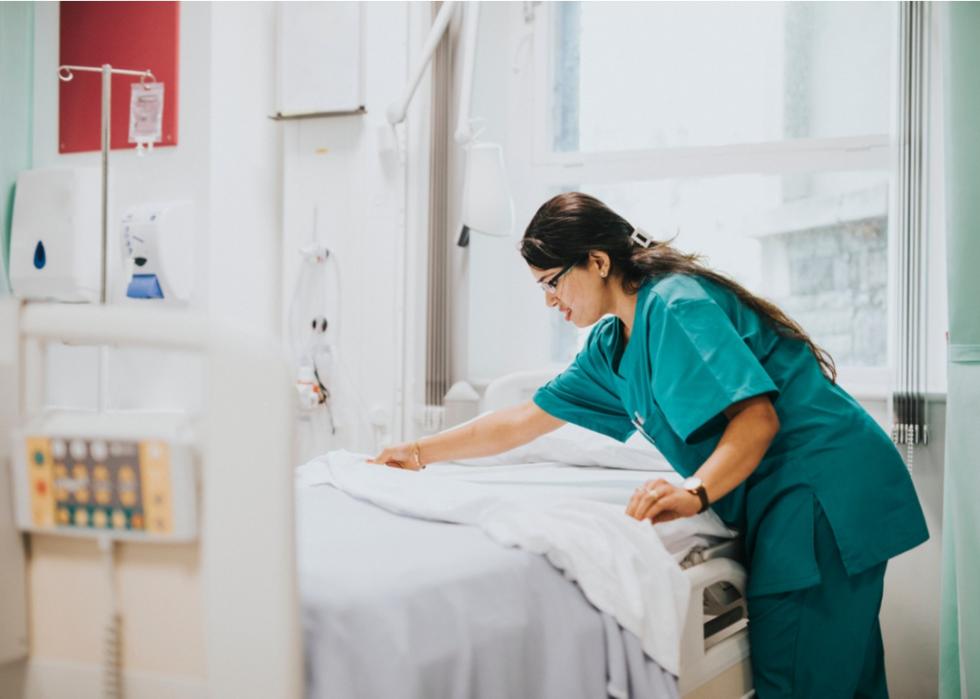 Nurse making hospital bed.