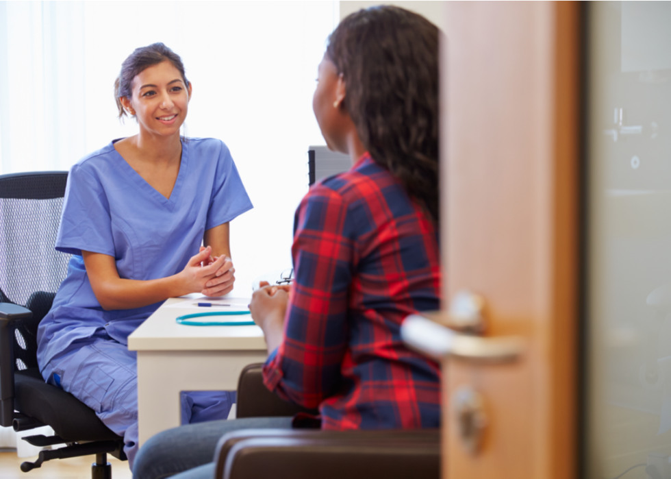 Nurse sitting and talking with patient.