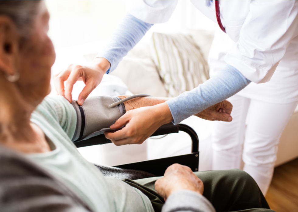 Nurse takes patient's blood pressure.