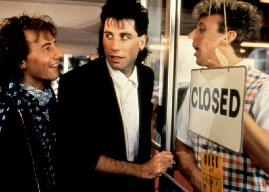 John Travolta and another guy trying to get into a door but a guy inside holds the closed sign up.