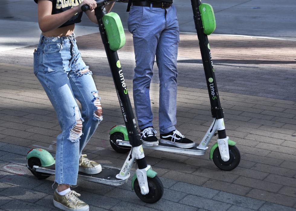 Teenagers ride rented scooters.