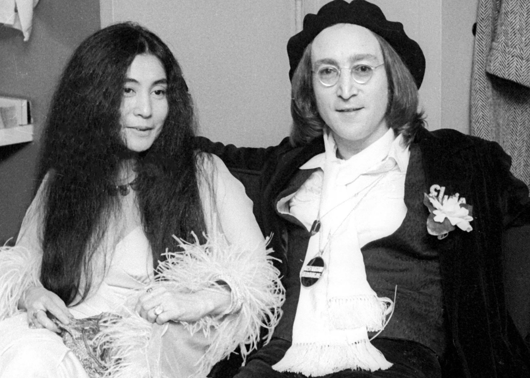 Yoko Ono and John Lennon seated in a dressing room.