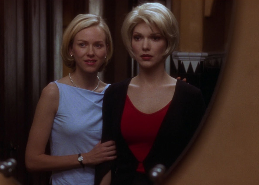 Laura Harring and Naomi Watts, almost identical, looking in a mirror together.