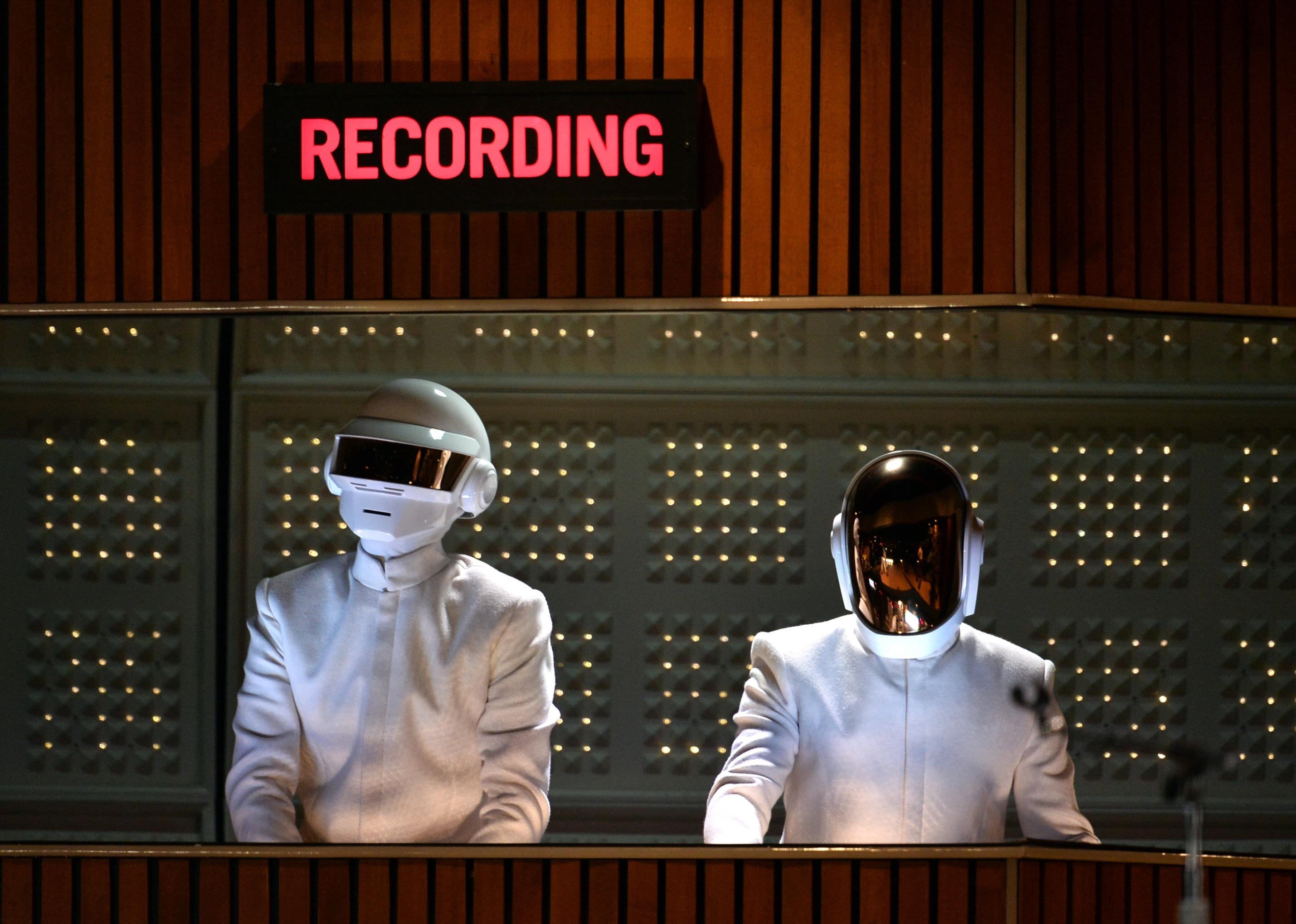 Daft Punk in white suits and helmets onstage.