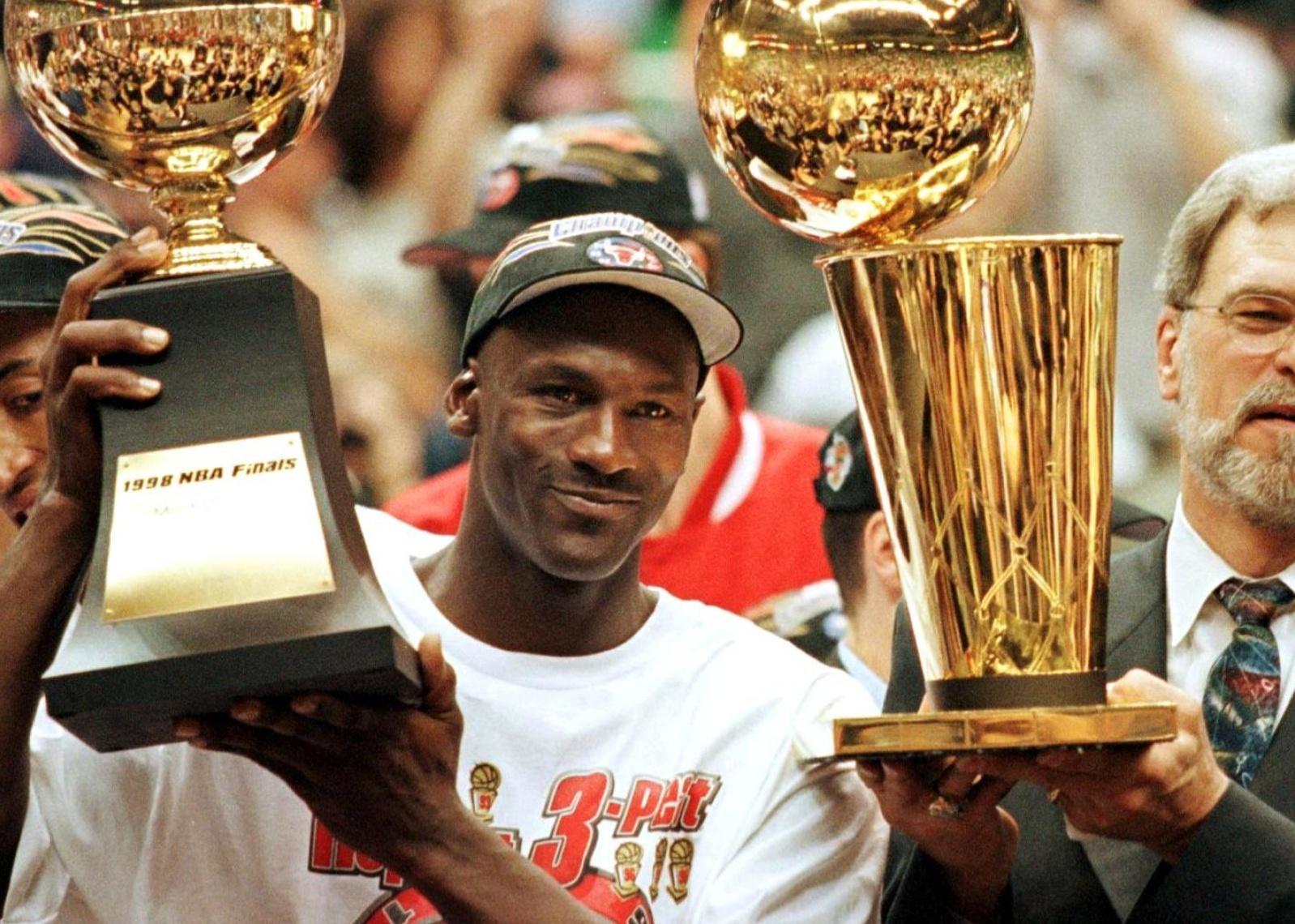Michael Jordan holding up a finals trophy.