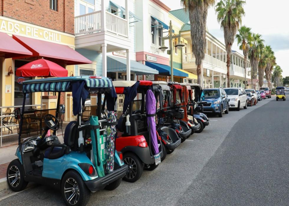 Colorful golf carts parked on downtown street.