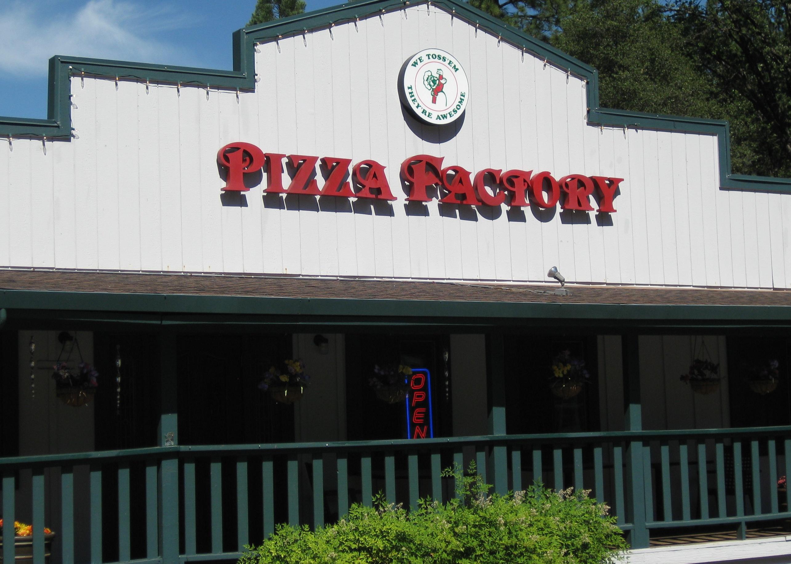 A green and white exterior location of Pizza Factory.