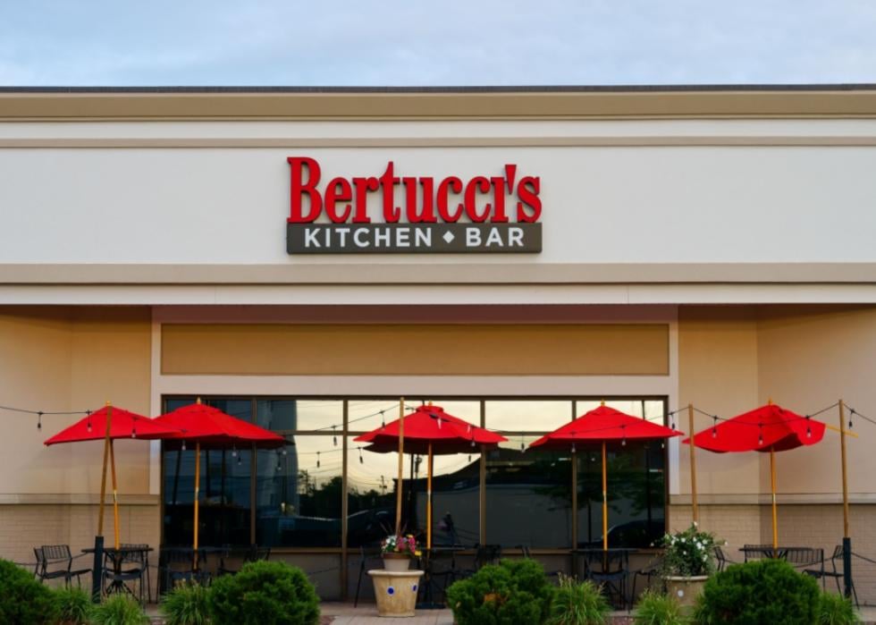 The exterior of a Bertucci's restaurant with red patio umbrellas.
