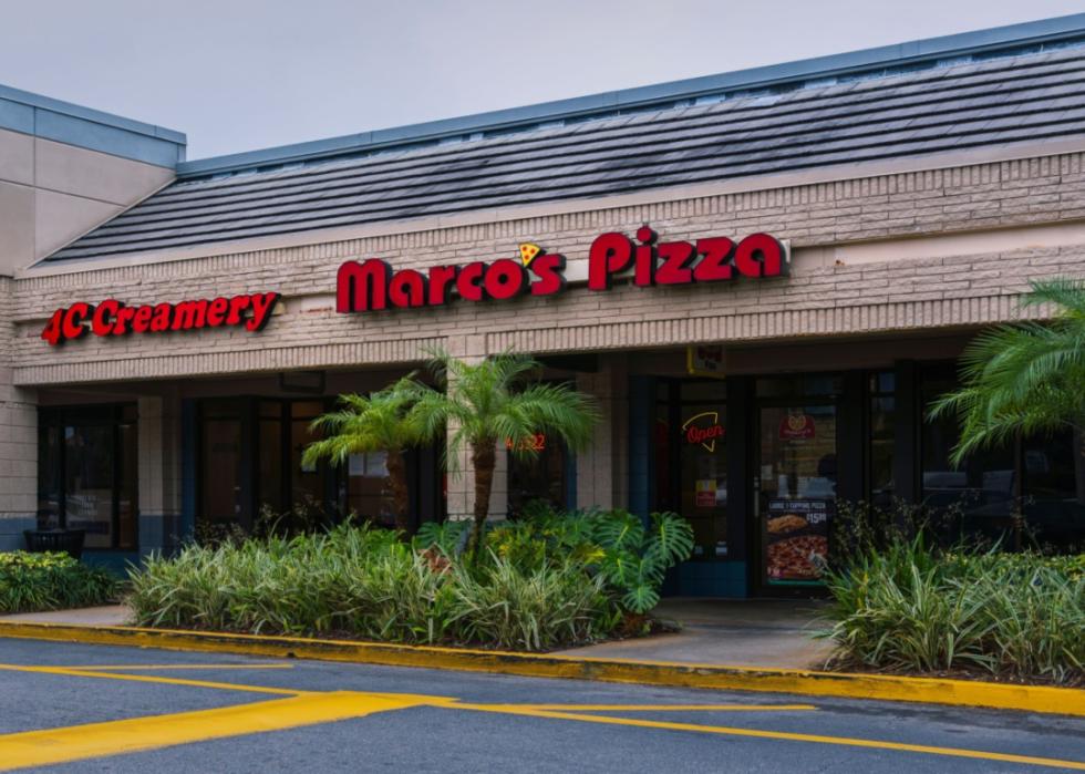 A Marco's Pizza exterior with palm trees.