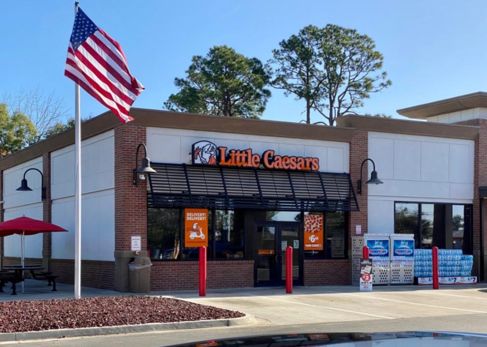 A Little Caesars storefront and American flag.