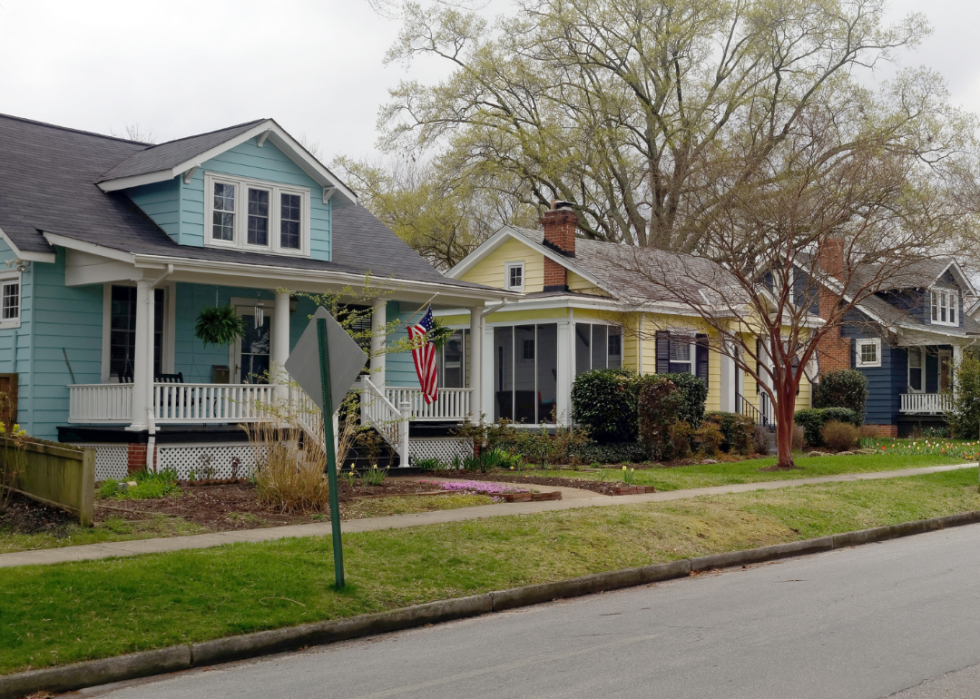 A street of small, colorful homes, one with an American flag hanging out front.