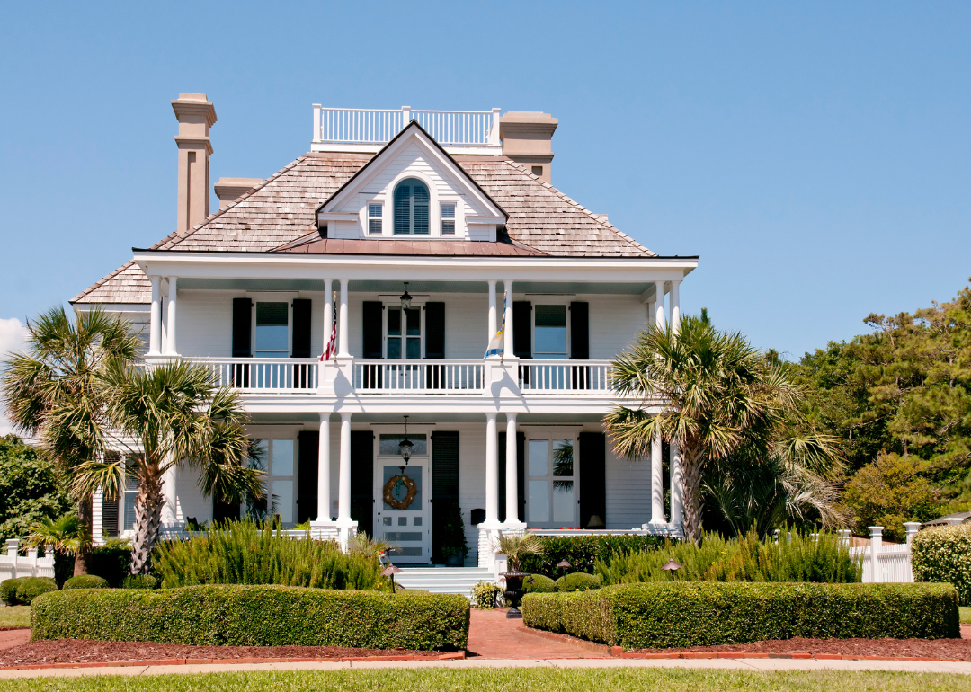 A historic white home with black shutters.
