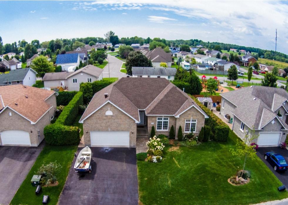 Overhead view of brick homes and driveways in a suburban neighborhood.