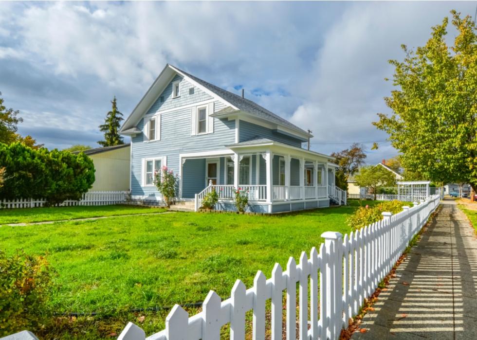 Blue Victorian home on green grass.