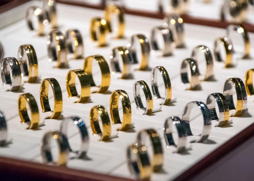 A box of gold and silver rings on display.