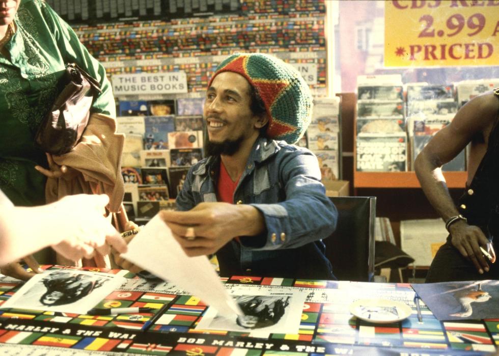 Bob Marley signing autographs in a record store.