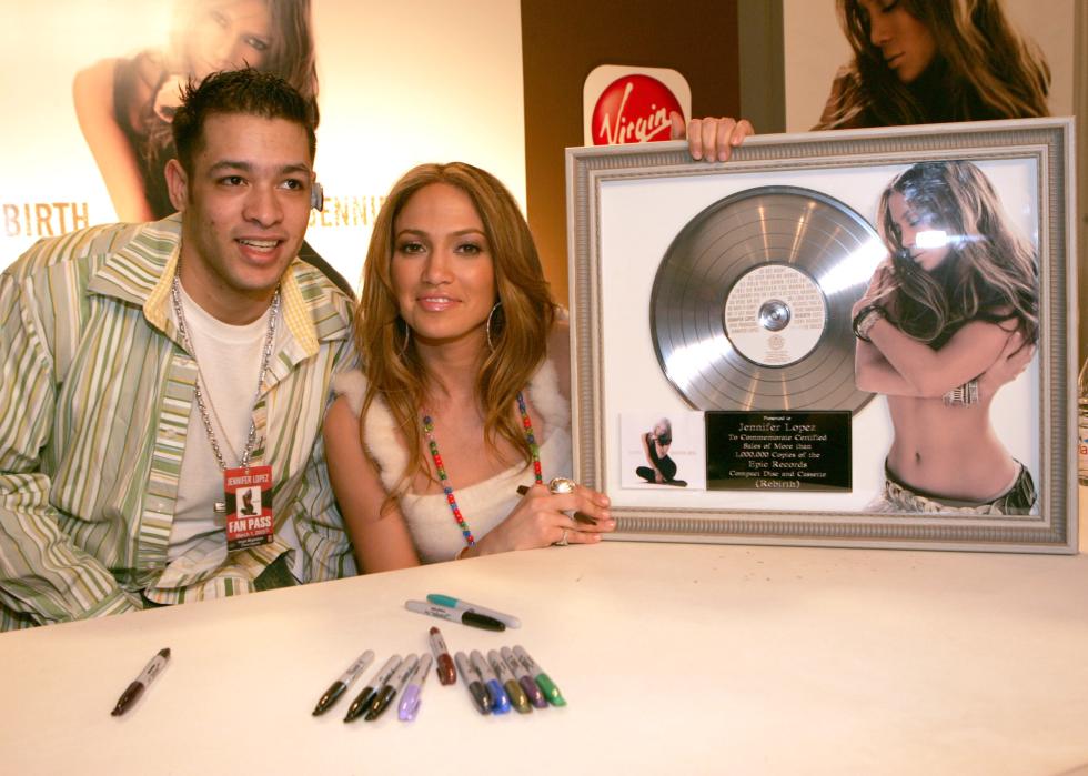 Jennifer Lopez poses with a fan at a Virgin Megastore.