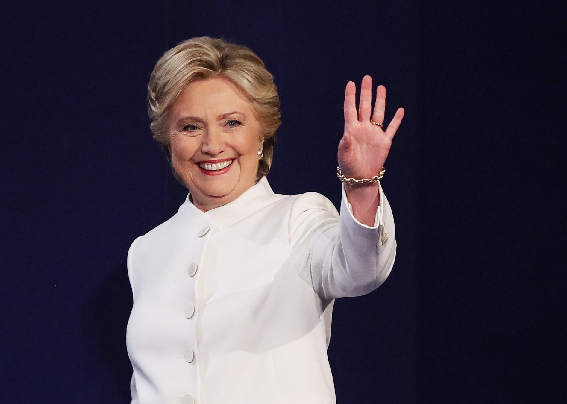 Hillary Clinton onstage in a white suit.