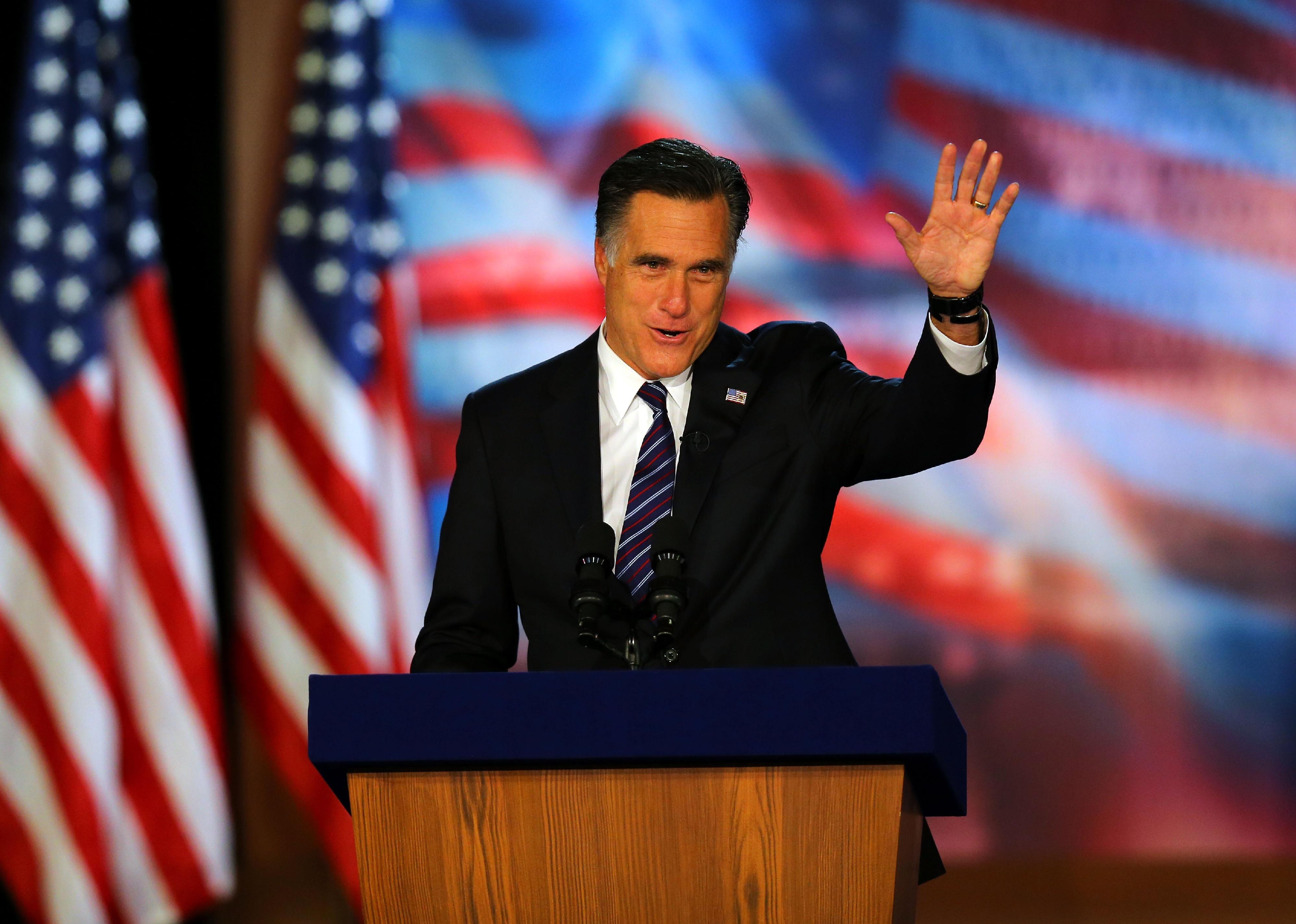 Mitt Romney waving onstage during a campaign speech.