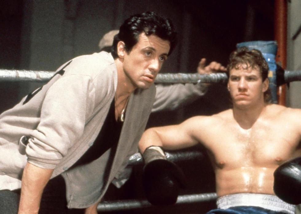 Sylvester Stallone and Tommy Morrison talking in the boxing ring during a fight.