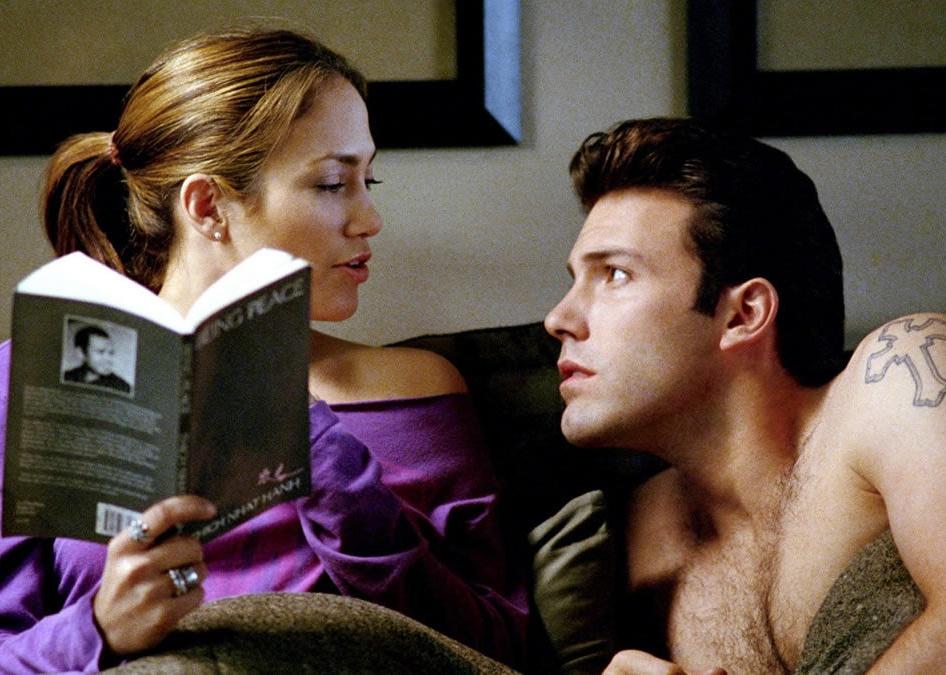 Jennifer Lopez reading a book to Ben Affleck in bed.
