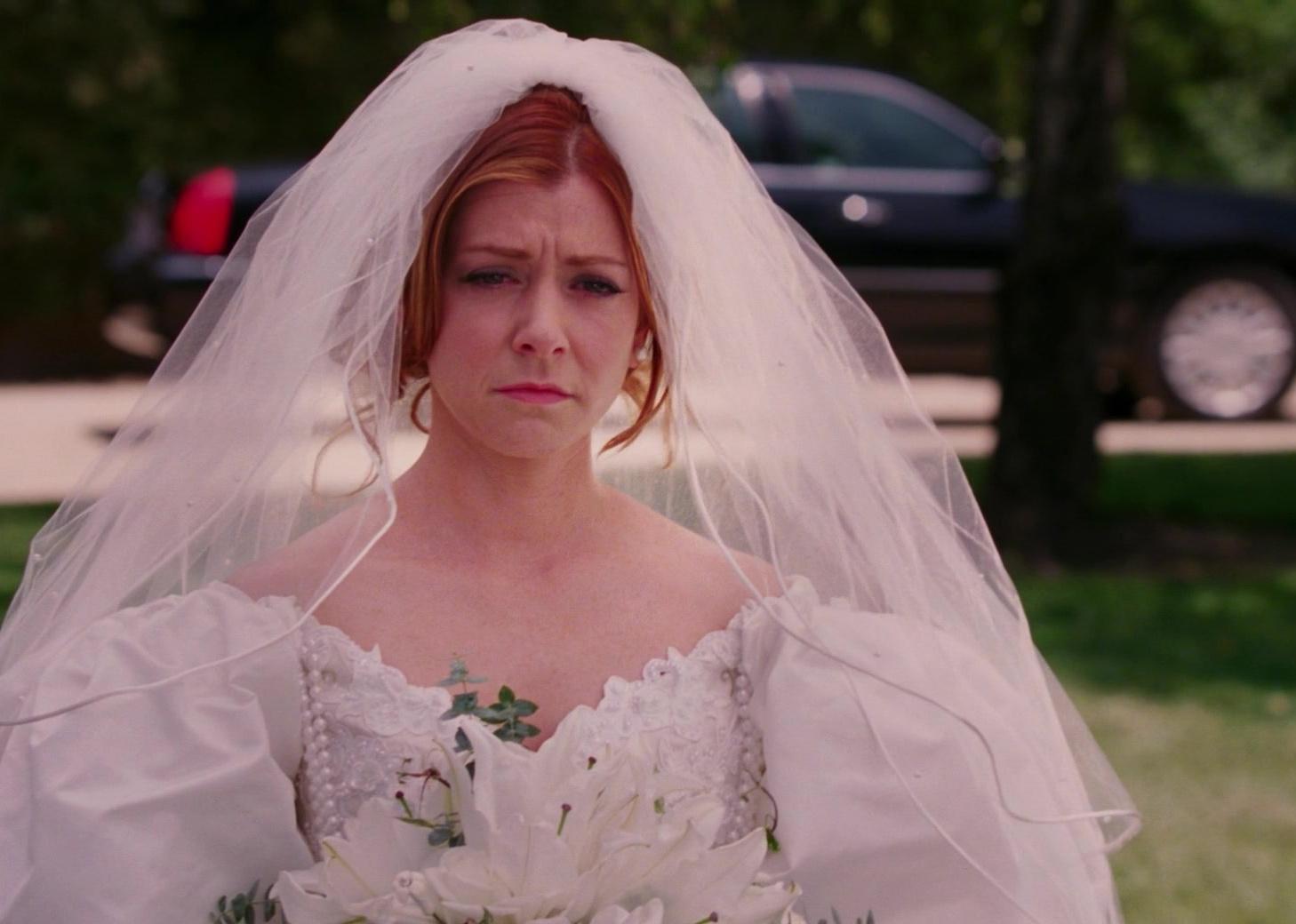 Alyson Hannigan looking sad in an oversized wedding dress.