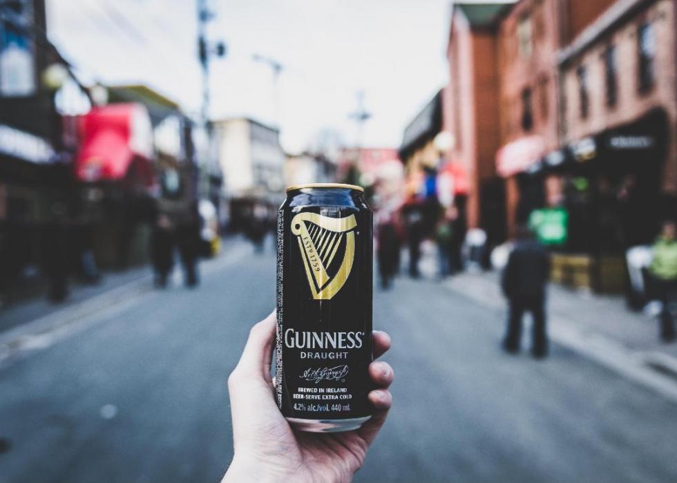 Person holding Guinness alcohol can.