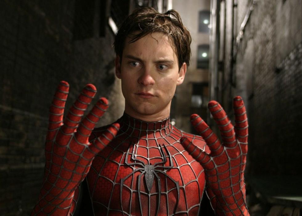 Spider man without a mask looks at his hands in awe.