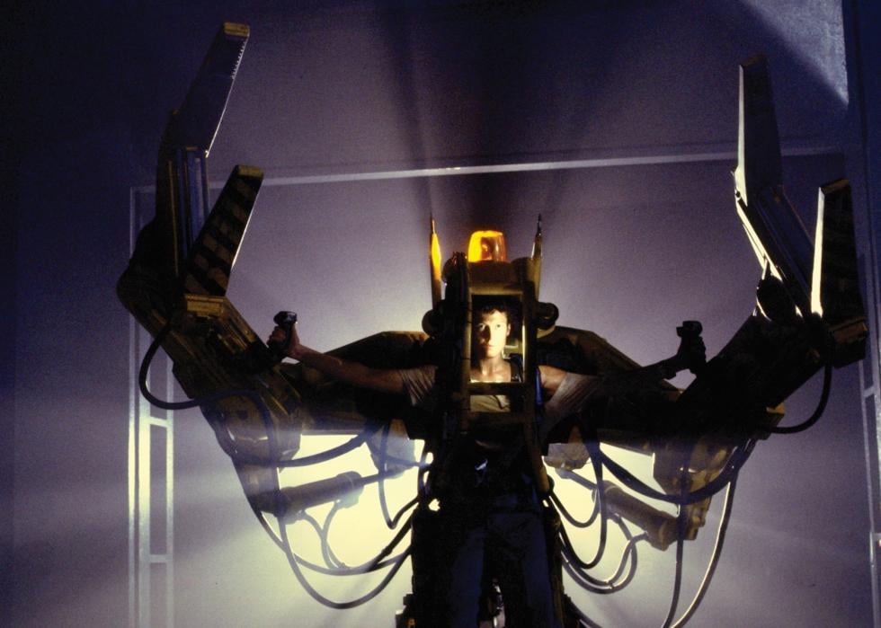 A woman in a giant robotic suit with metal arms on the sides and lights on top.