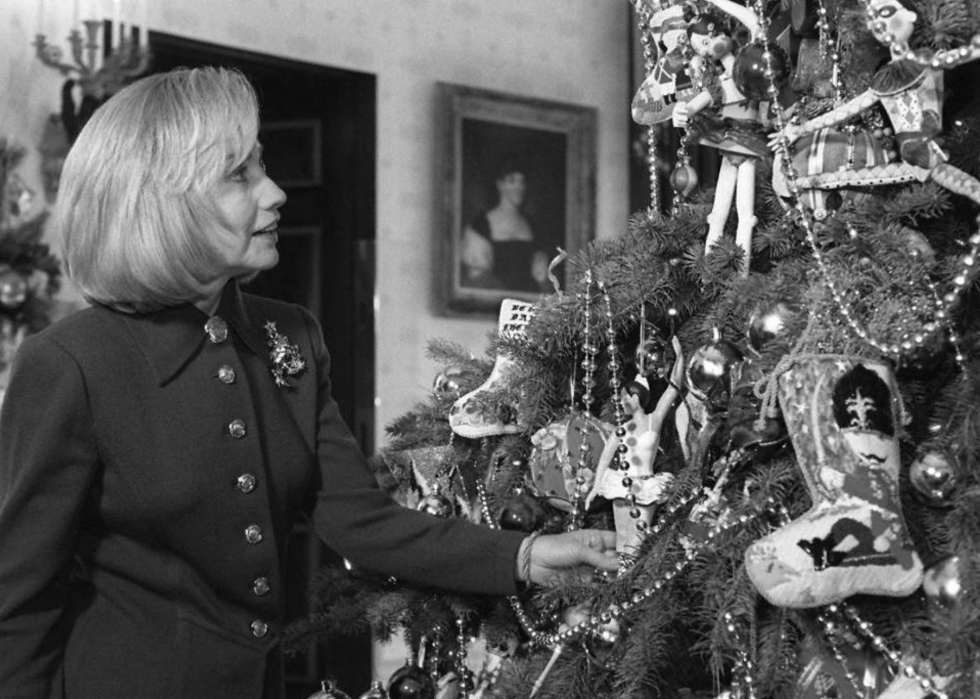 Hillary Clinton looks at Christmas ornaments on the White House tree.