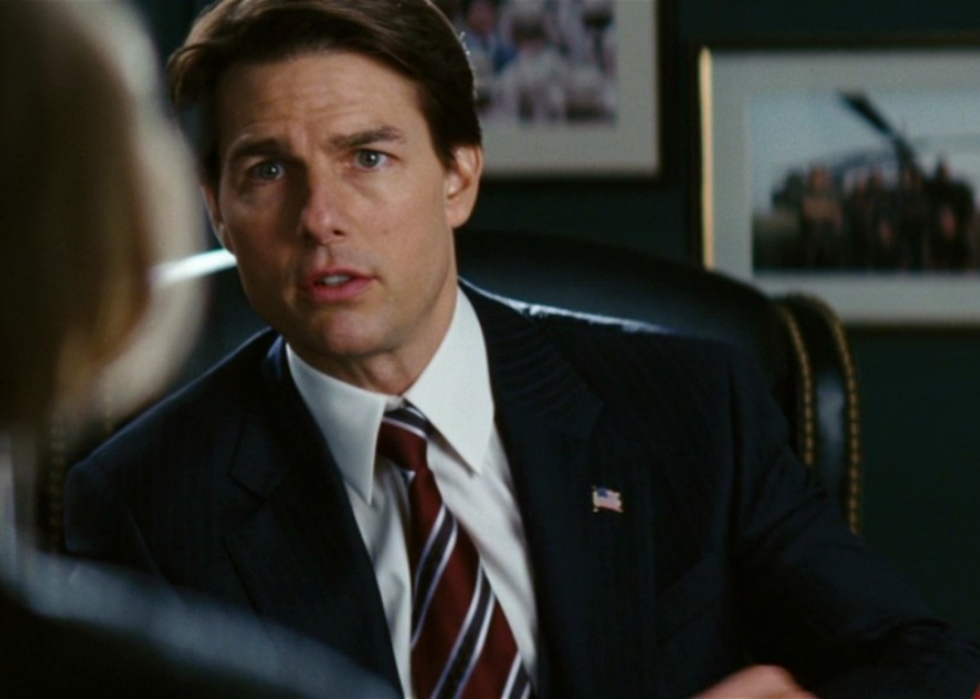 Tom Cruise in a suit at a desk.