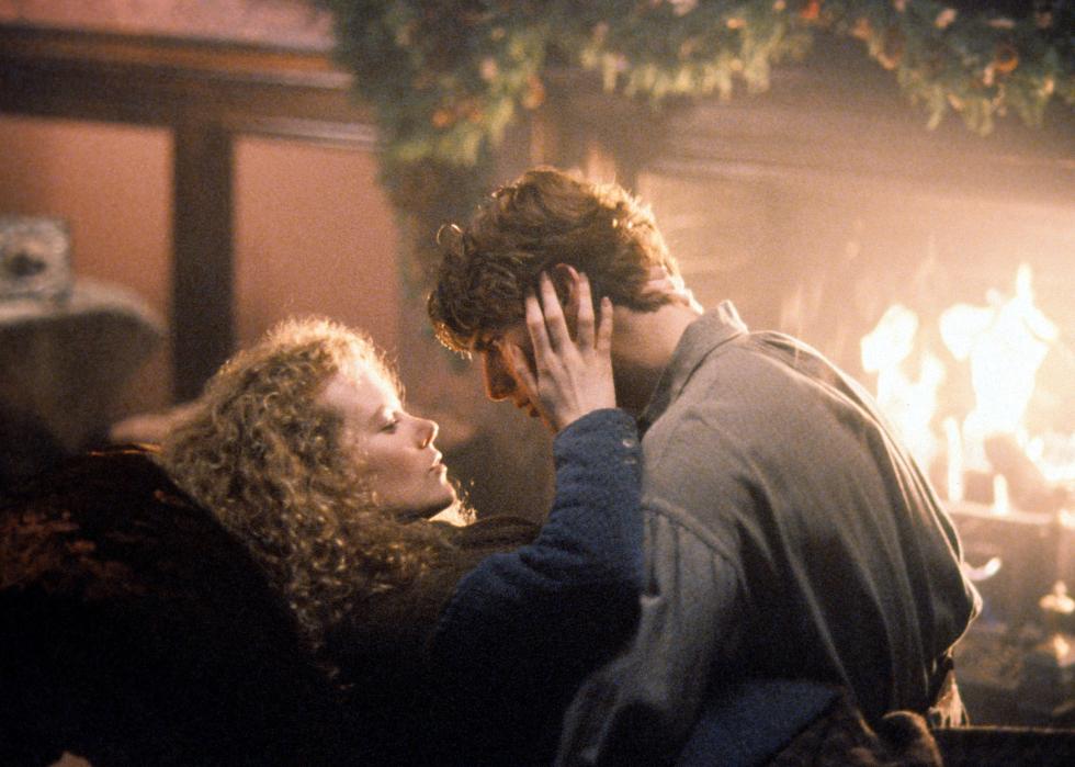 Tom Cruise and Nicole Kidman stare into each other's eyes in front of a fireplace.