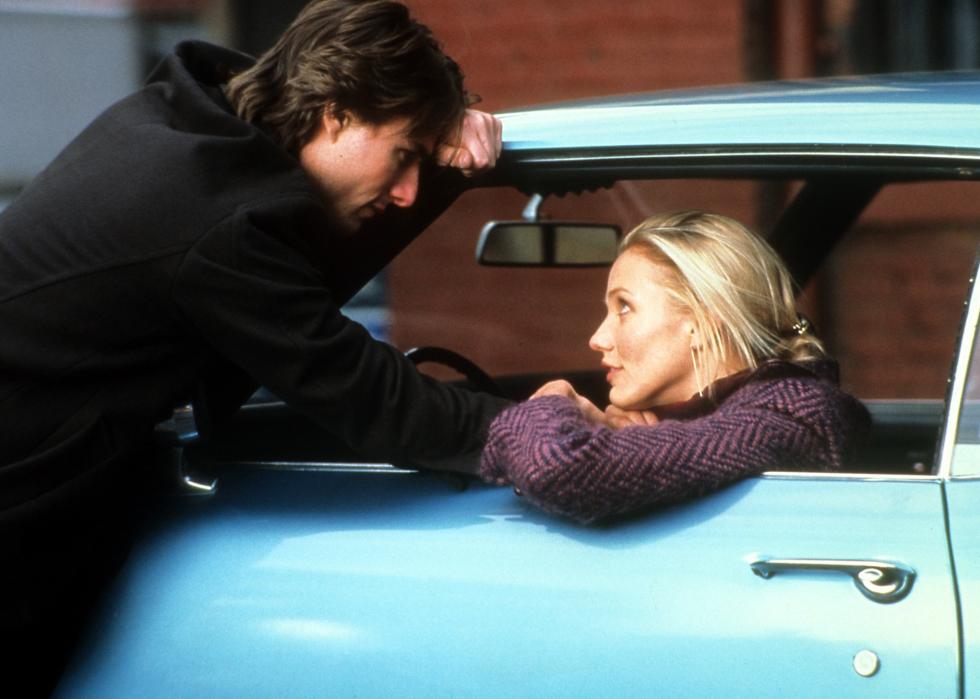 Tom Cruise talks to Cameron Diaz as she sits in a blue classic car.