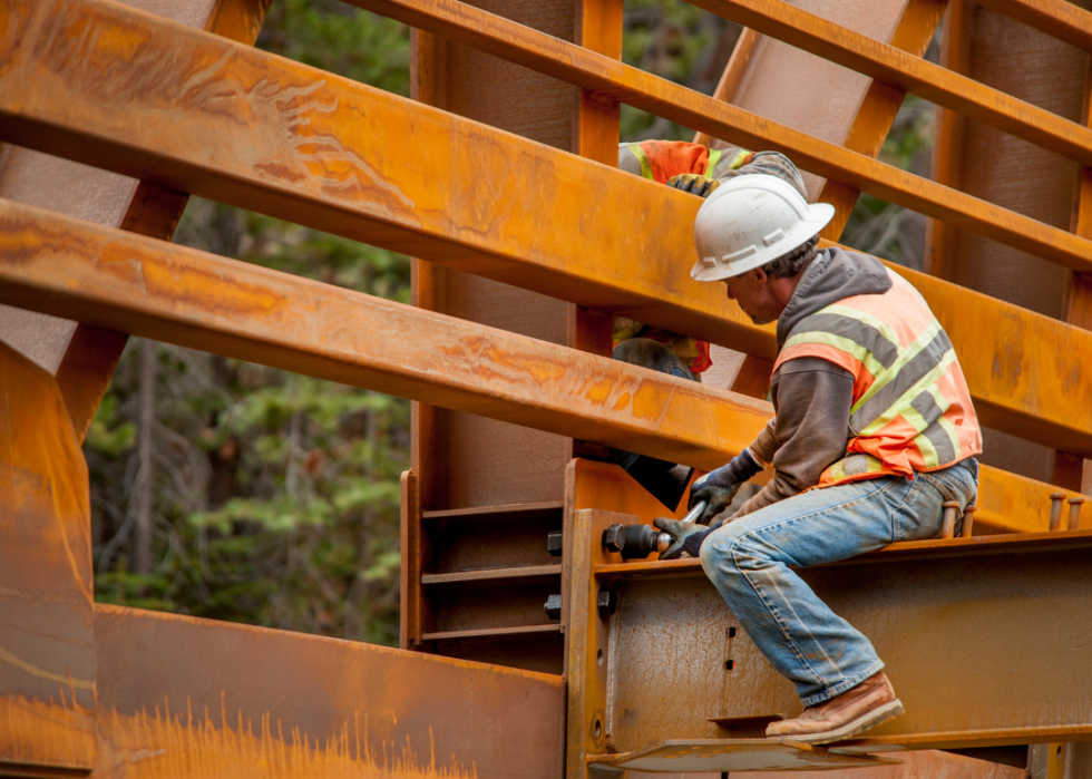 Two men working on steel bridge construction.