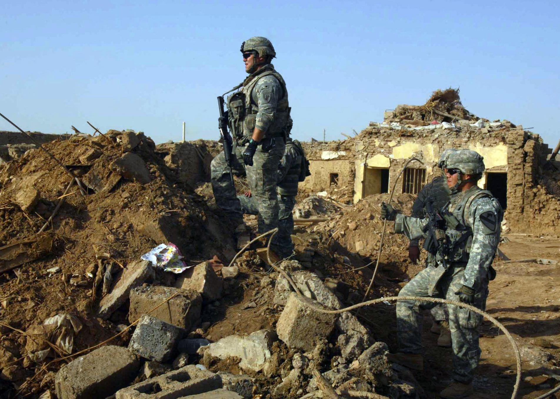 U.S. Army soldiers surveying damage in Iraq after a blast.