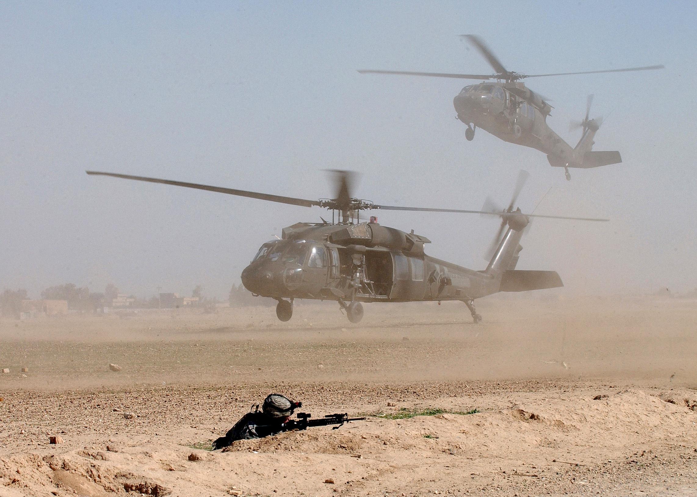 Blackhawk helicopters landing on the battlefield to pick up U.S. soldiers.